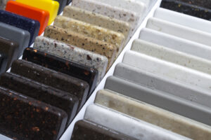 Samples of natural granite, marble, quartz stone, countertops and a sample of natural parquet. Model made of stones, close up. Modern colored slabs made of natural stone.